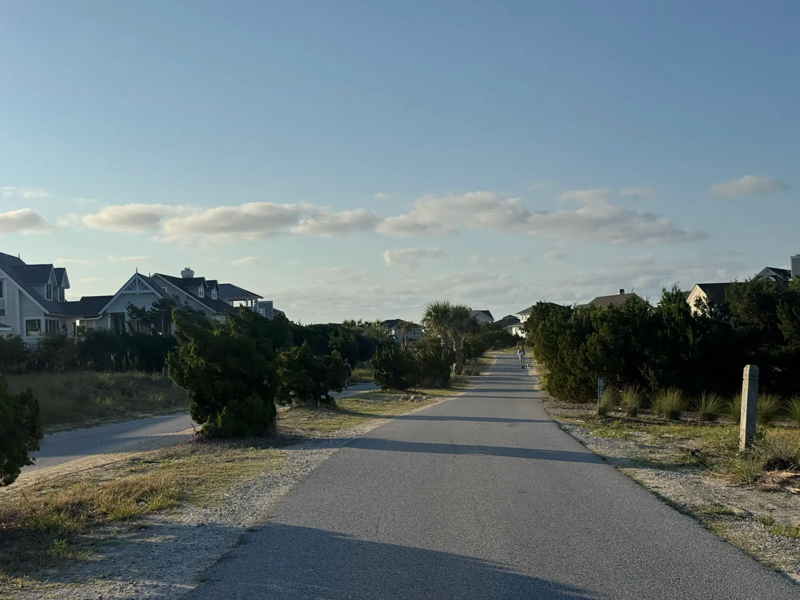 A long straight beach-area path between cottages and dunes