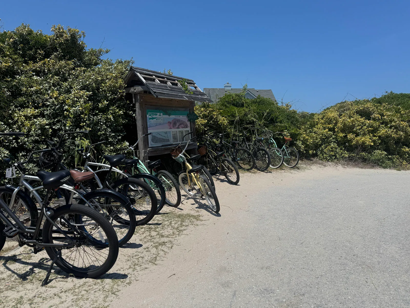 Beach access path with parked rental bikes and info kiosk
