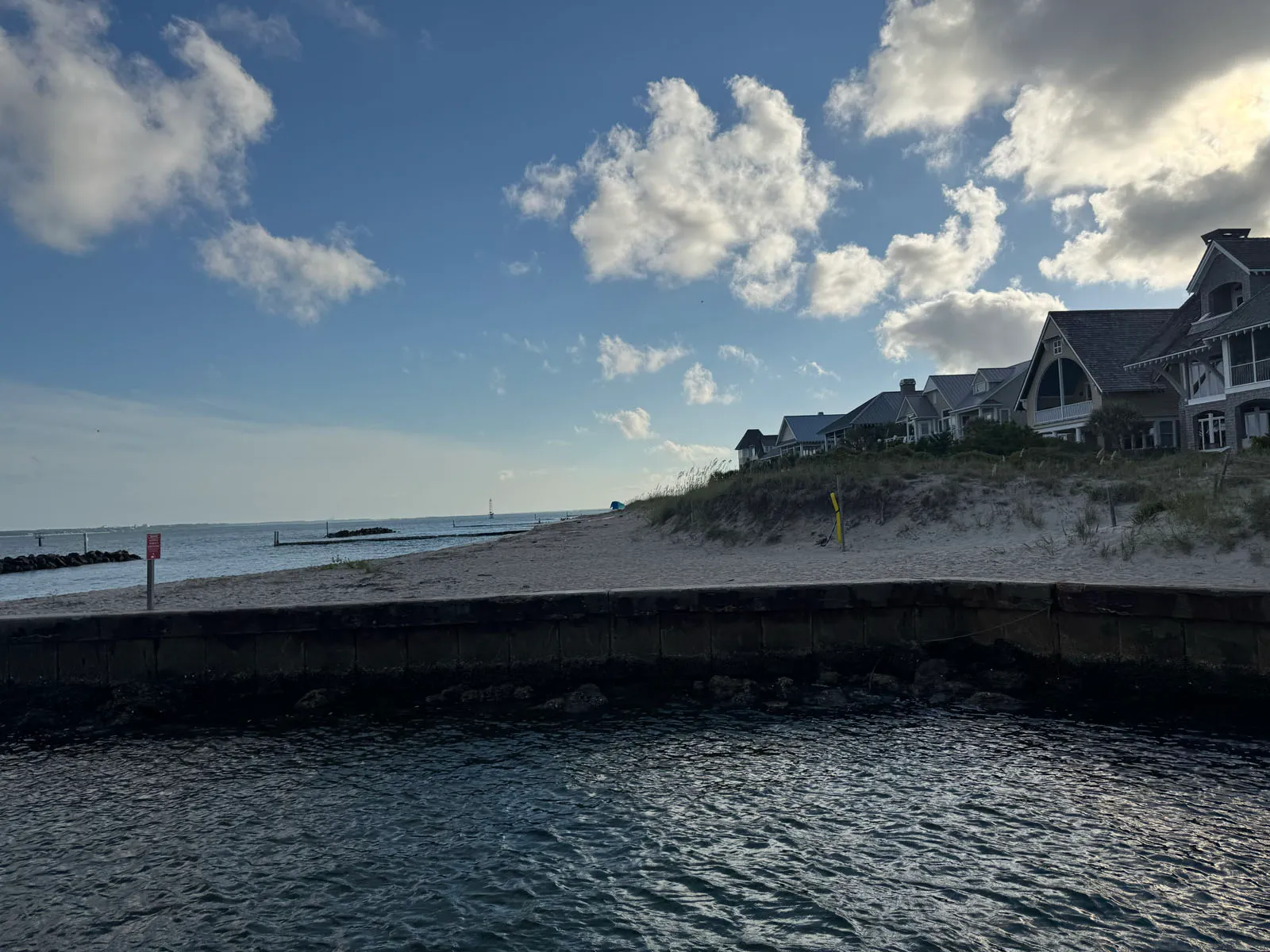 Beach point with coastal homes and jetty at inlet
