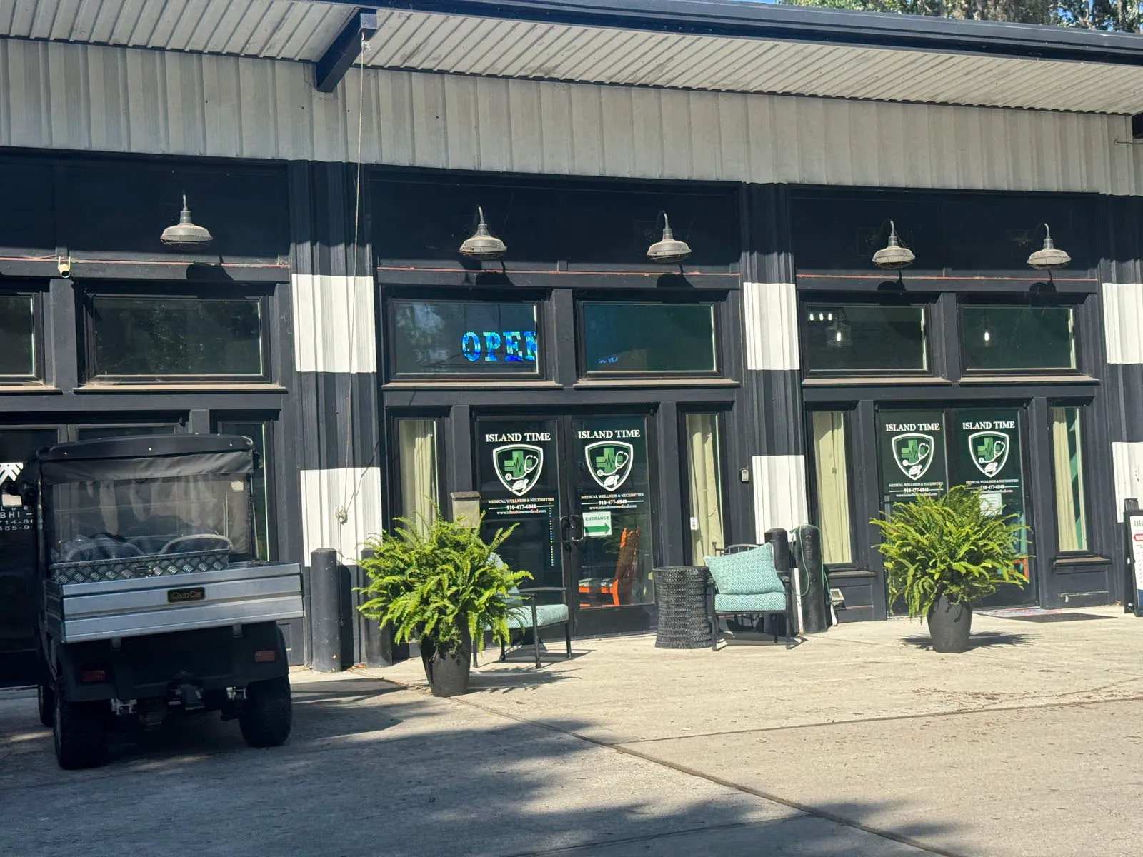 Island Time storefront wide view with golf cart and OPEN sign