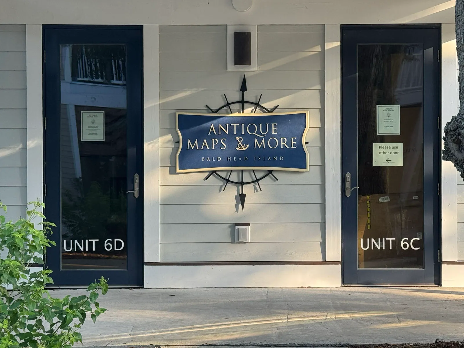 Antique Maps & More storefront sign between unit doors
