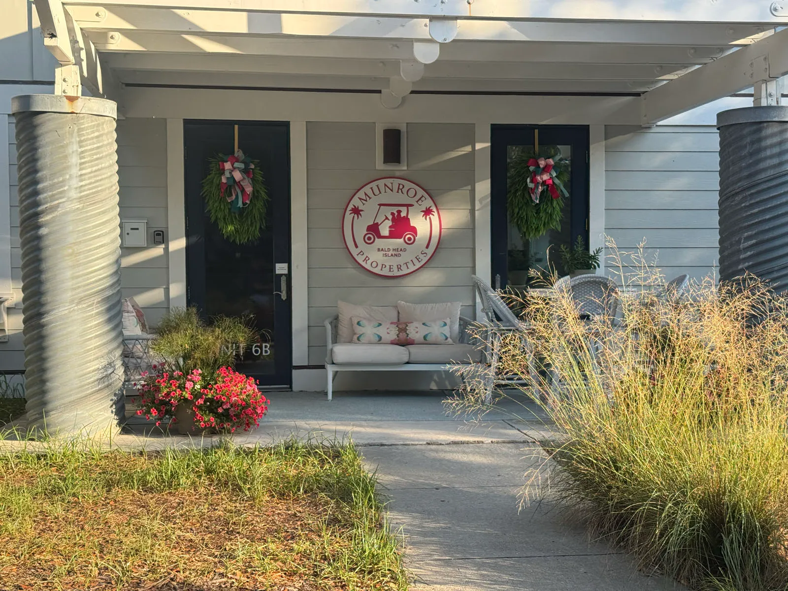 Munroe Properties porch entrance with logo and holiday wreaths