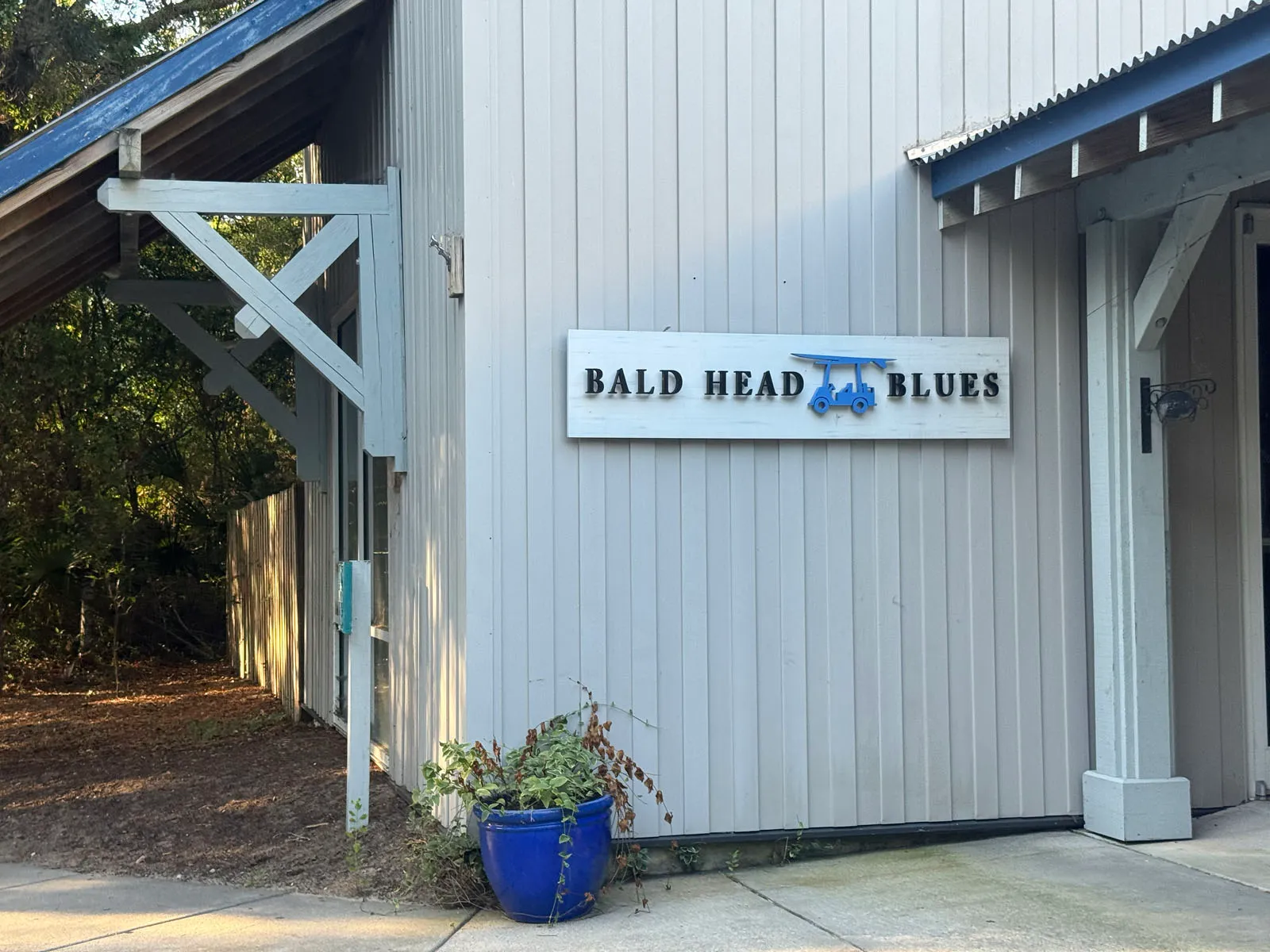 Bald Head Blues shop exterior sign with golf cart logo