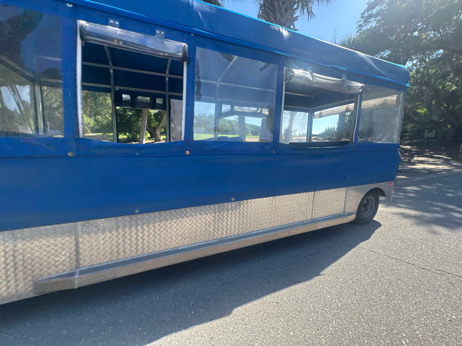 Blue open-air island tram/tour trolley on road