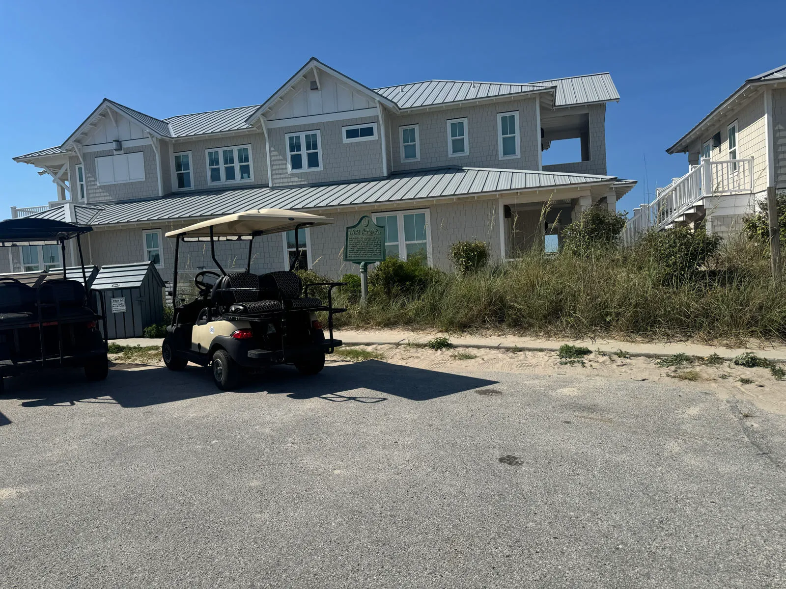 Parked golf cart before large shingled beach house