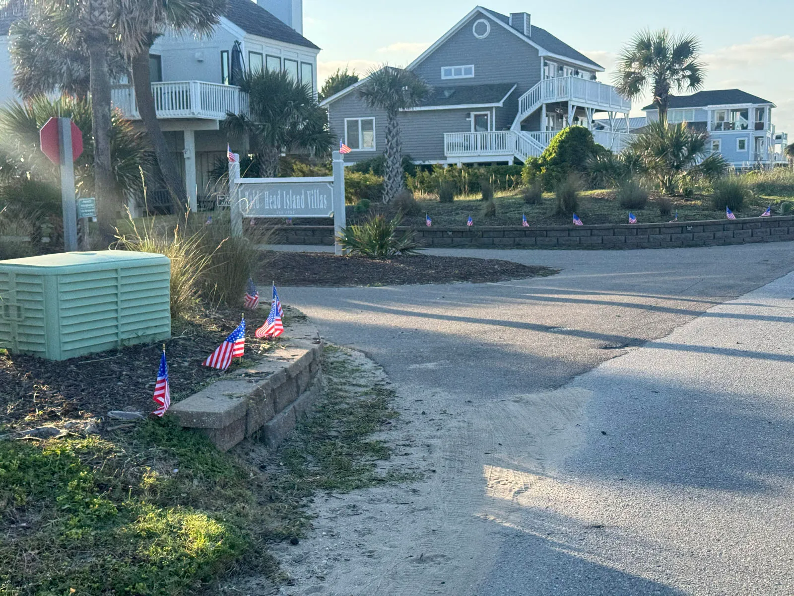 Bald Head Island Villas homes and sign, US flags lining walk