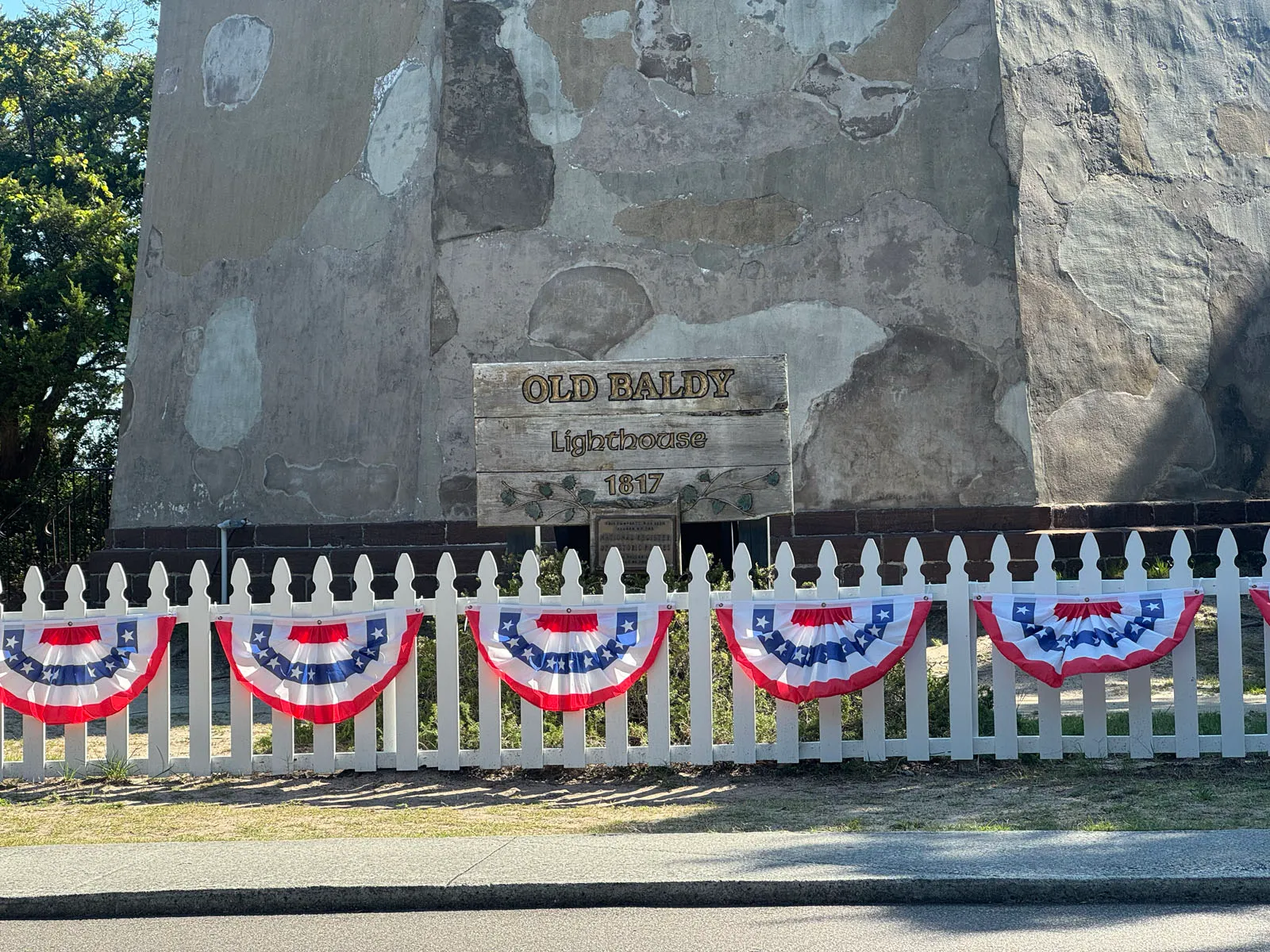 Base of Old Baldy lighthouse with plaque and bunting fence