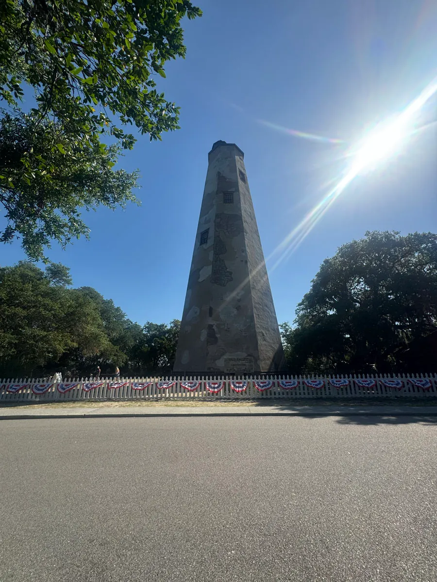 Old Baldy lighthouse tower against sun with lens flare