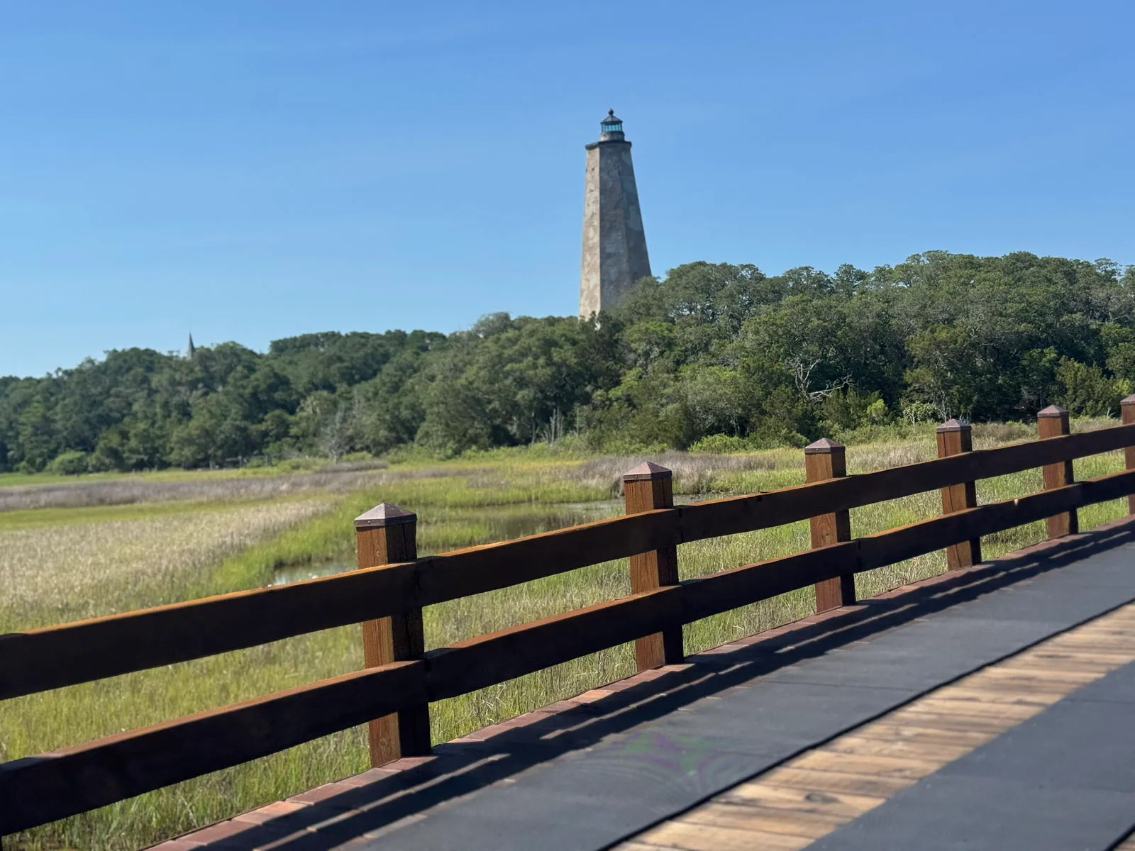 Old Baldy lighthouse over marsh viewed from boardwalk rail