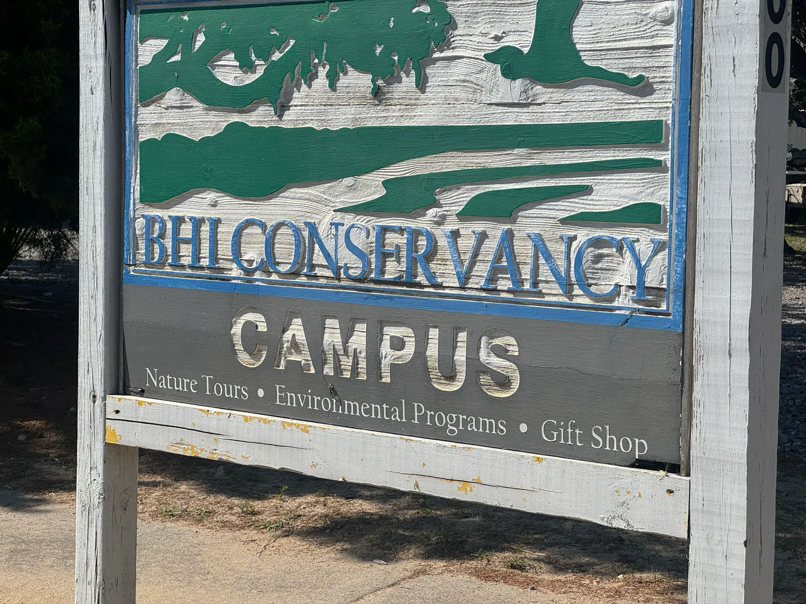 Weathered BHI Conservancy Campus wooden sign closeup