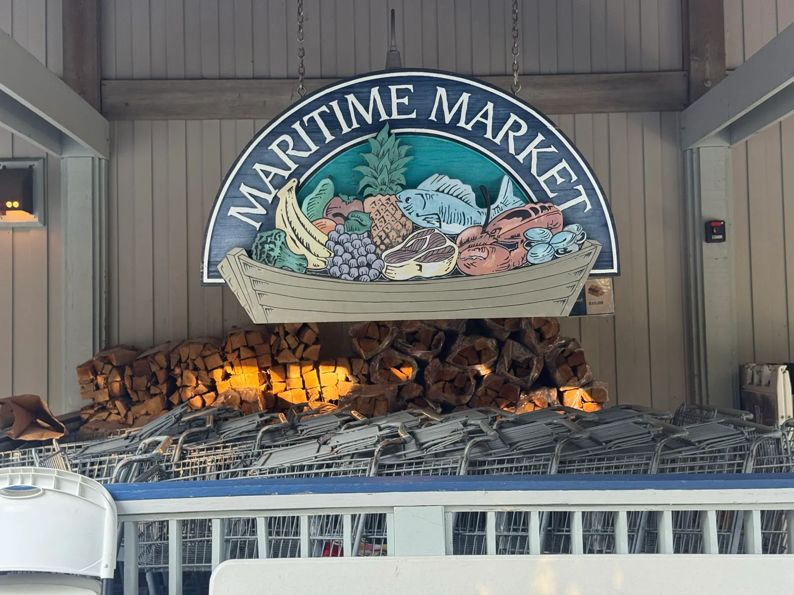 Maritime Market carved wooden sign over firewood and carts