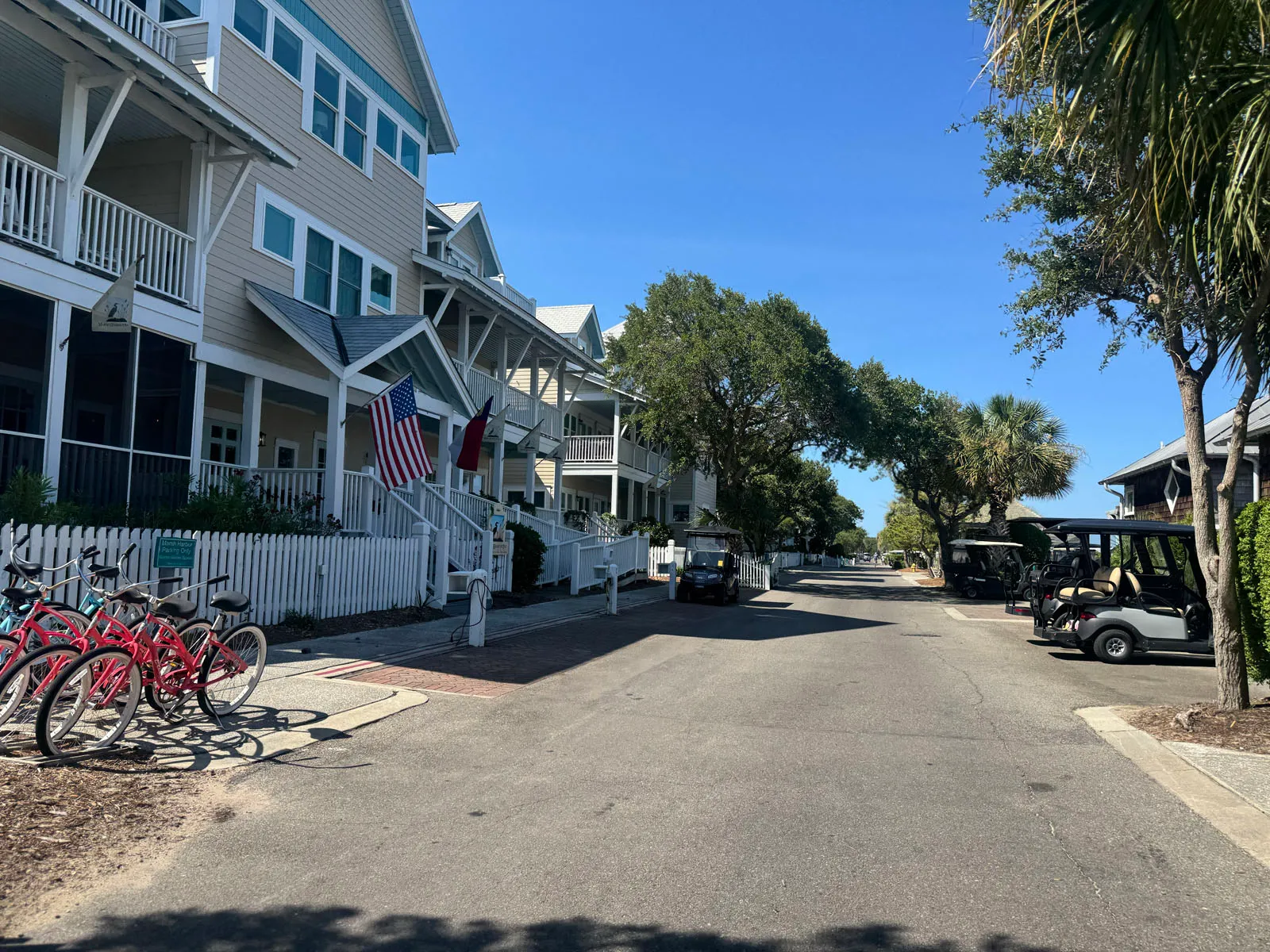 Village street with bikes, flags, cottages, and golf carts